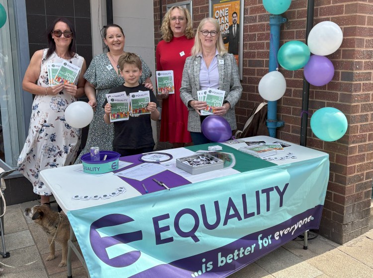The Equality Party team standing behind a stall with Equality is better for everyone written on.