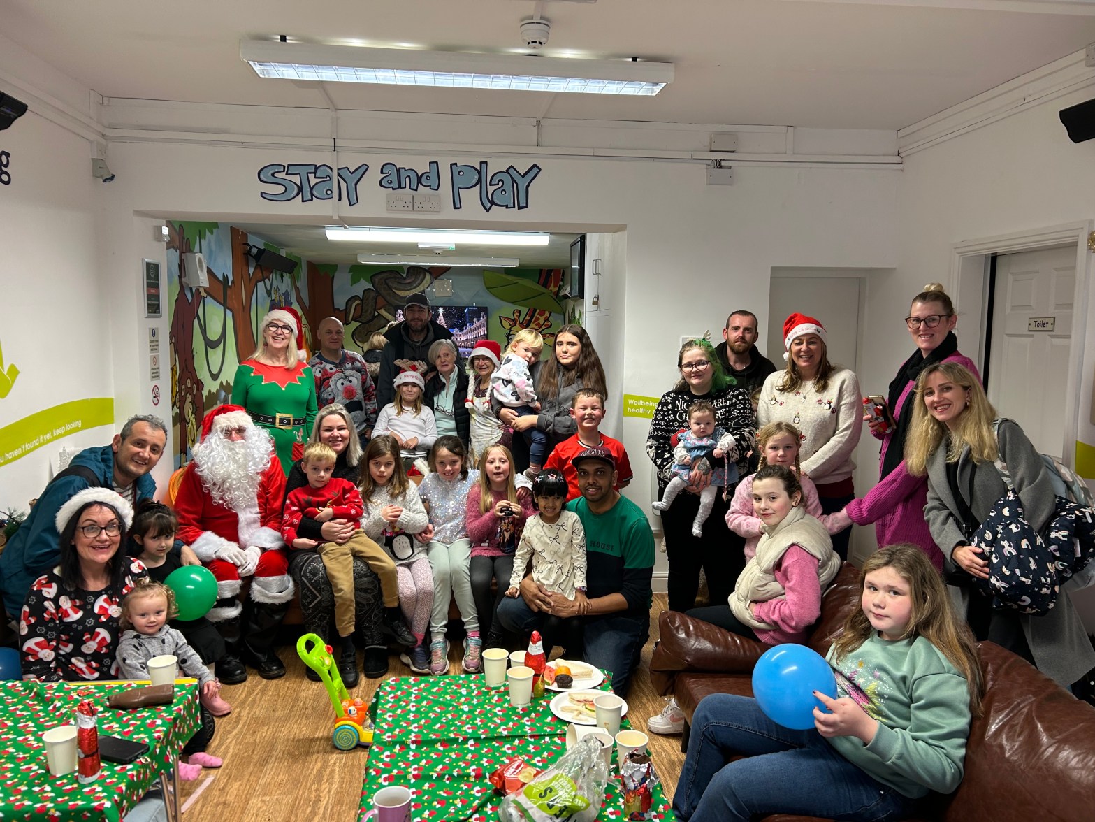 Large group of adults and children in a festive setting