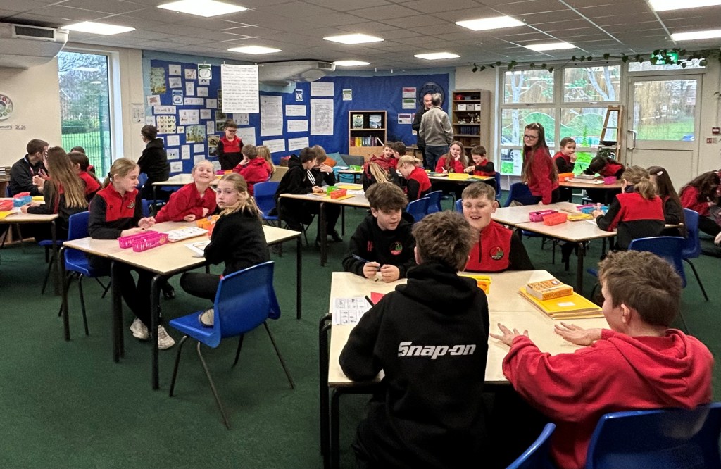 Blackfirs students role-playing challenging gender stereotypes - an image of a classroom with 10 and 11 year olds working in groups at desks.