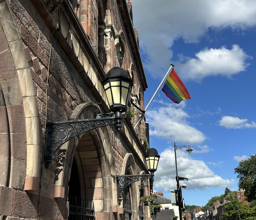 Image of Pride rainbow flag on town hall.
